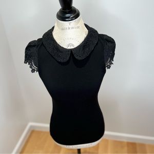 Black stretchy top with lace collar and sleeves.
